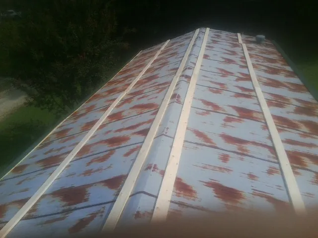 Rusted metal roof panels with new wood purlins before replacement — Storm Damage Roof Repair in Lisbon by Roofing Brothers